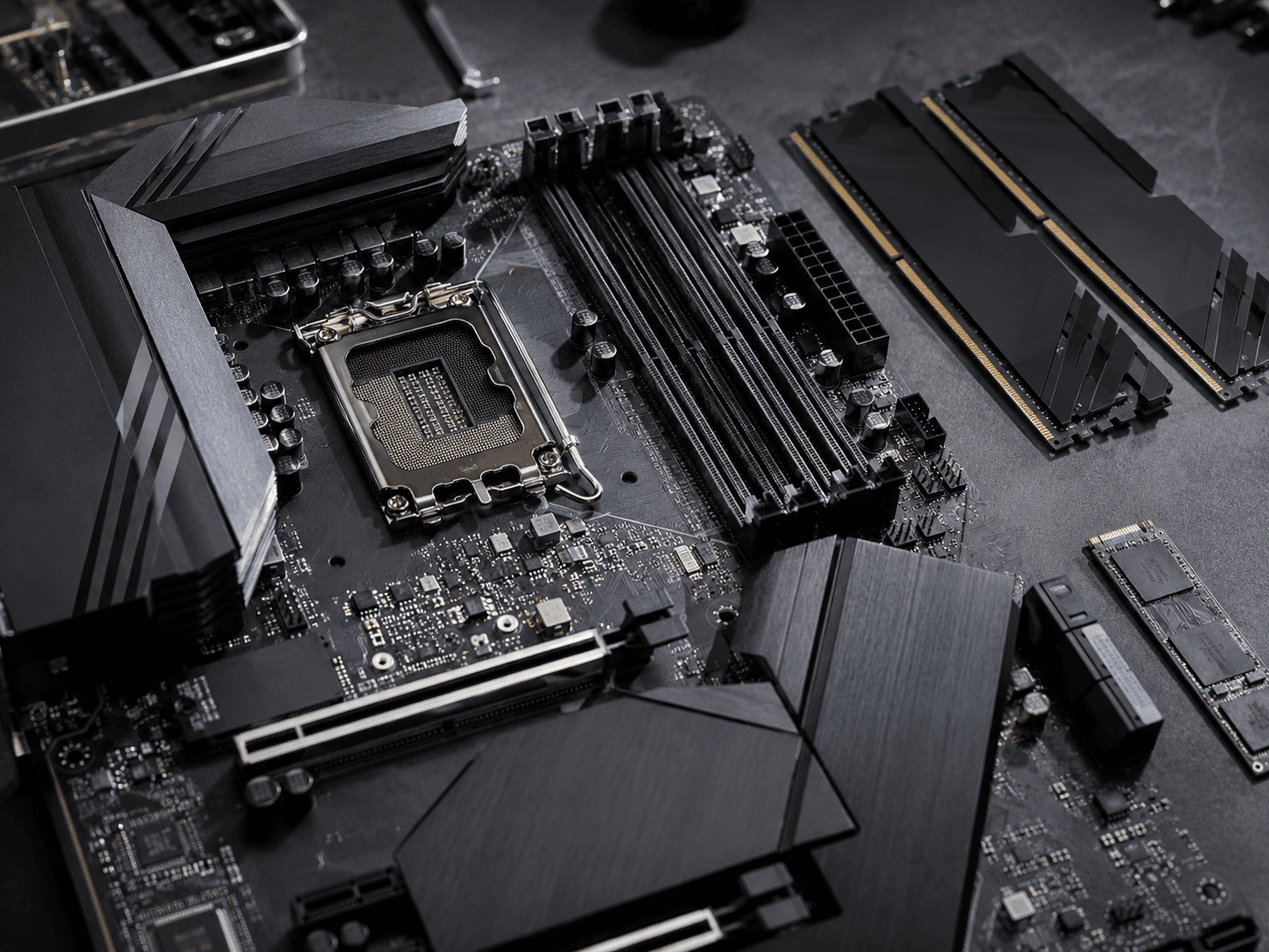 Motherboard, memory modules and drives laid out on a dark surface